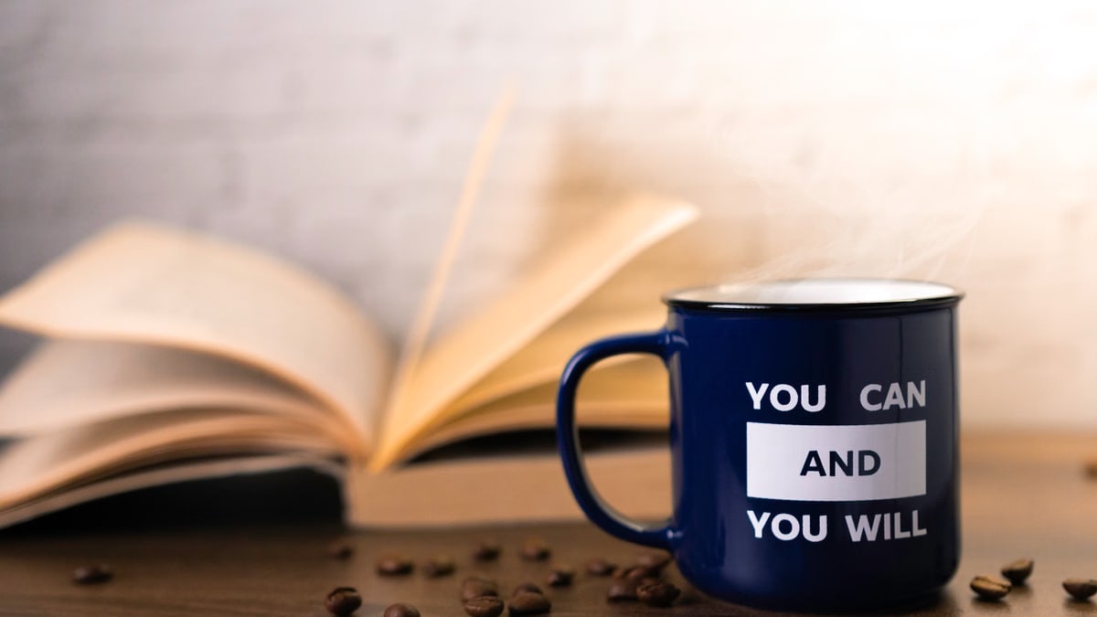 Motivational mug with an open book and coffee beans, perfect for inspiring your day.